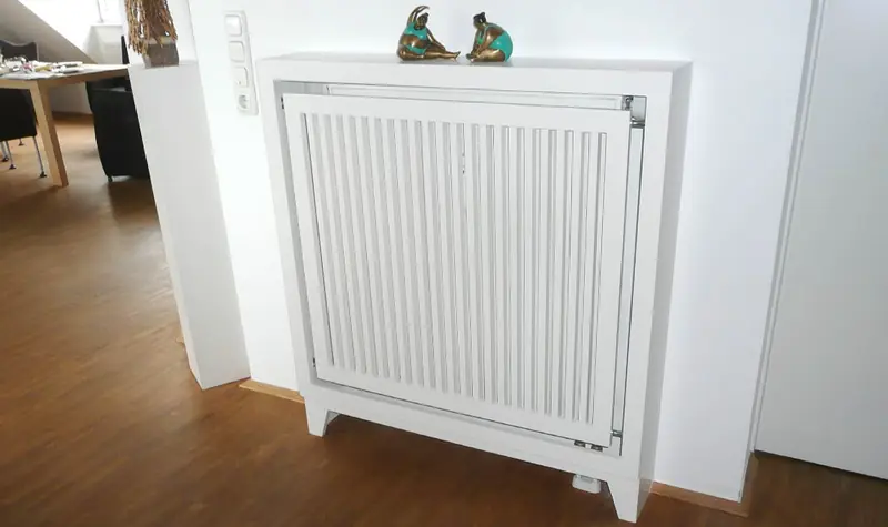 Weiße Heizkörperverkleidung aus Holz mit Ablage in einem Wohnraum