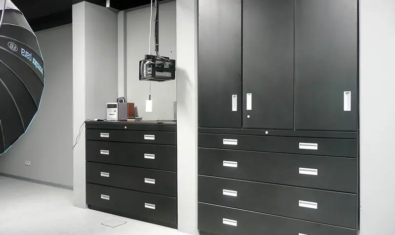 Dunkle Einbauschrankwand mit Schubladenauszügen in einem Studioraum