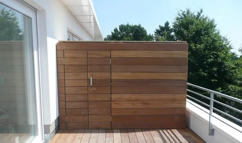 Holzverkleideter Außenschrank aus waagerechten Latten auf einer Dachterrasse